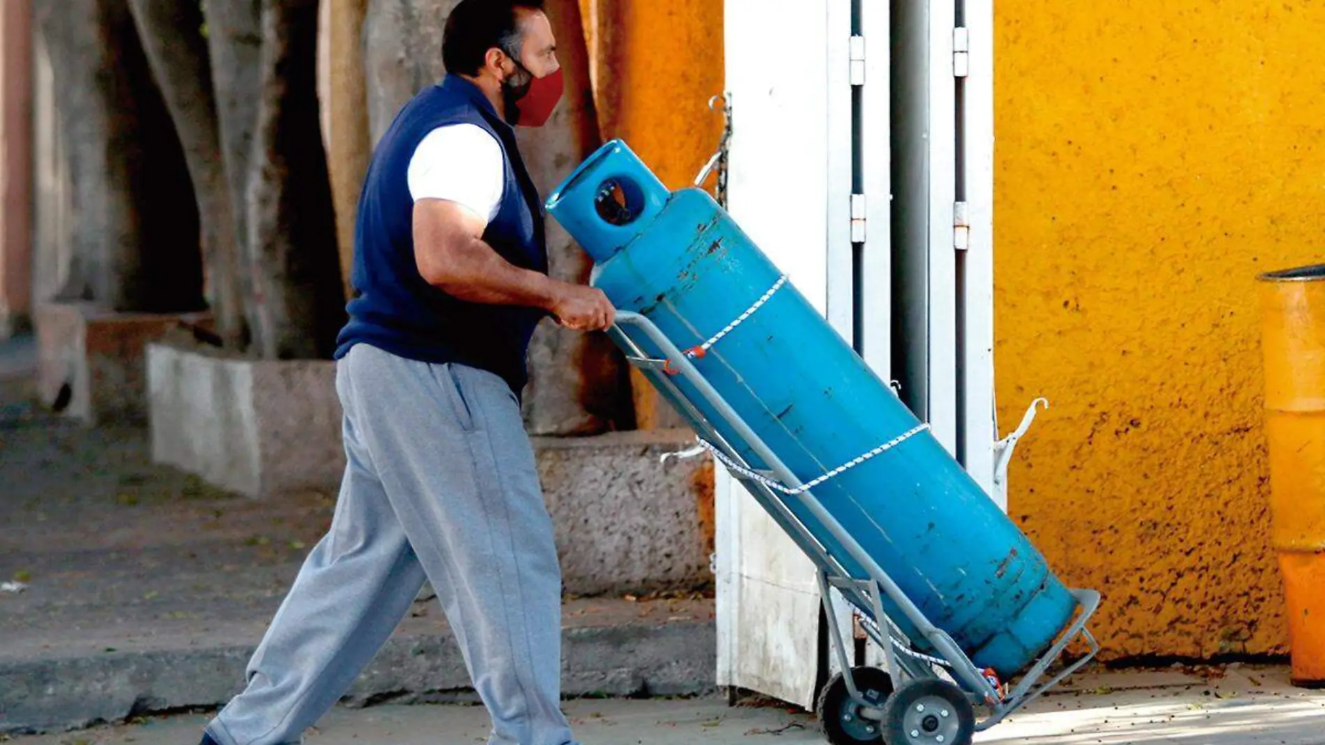 Hombre transportando cilindro de gas